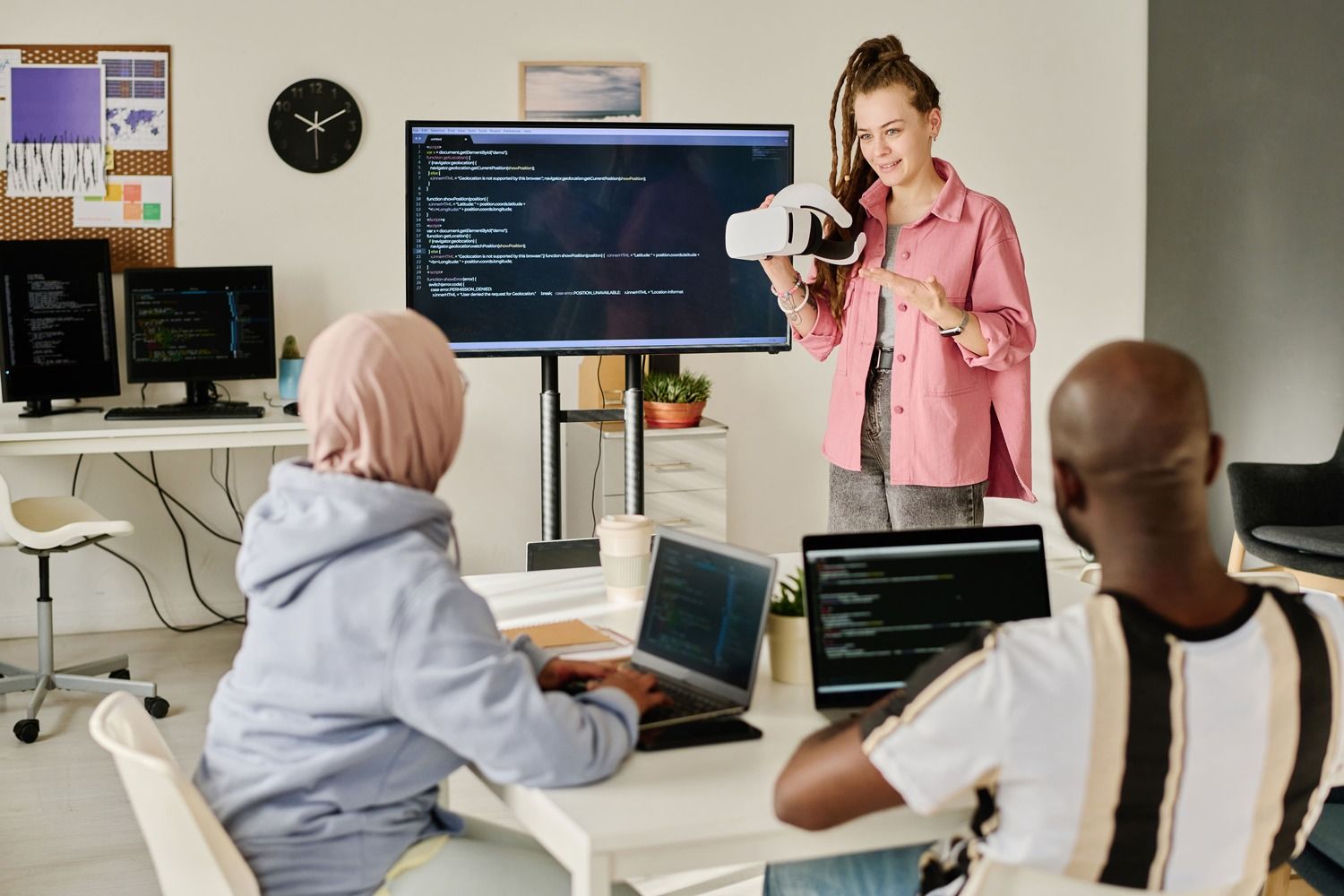 programmer-presenting-vr-glasses-to-her-colleagues-2025-02-11-15-37-40-utc.jpg